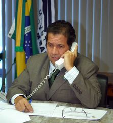 Ministro Carlos Lupi durante telefonema a um trabalhador que tem direito a sacar o abono salarial.